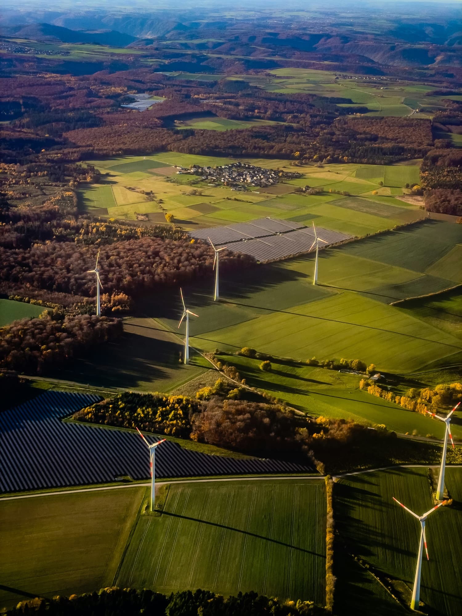 Wind turbines and solar arrays integrated into a rural landscape